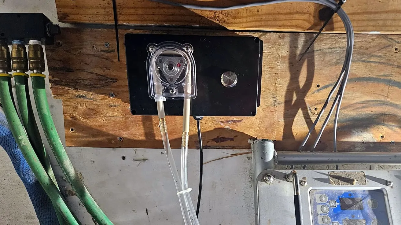 Peristaltic pump box mounted above a Graco Reactor E-20 proportioner