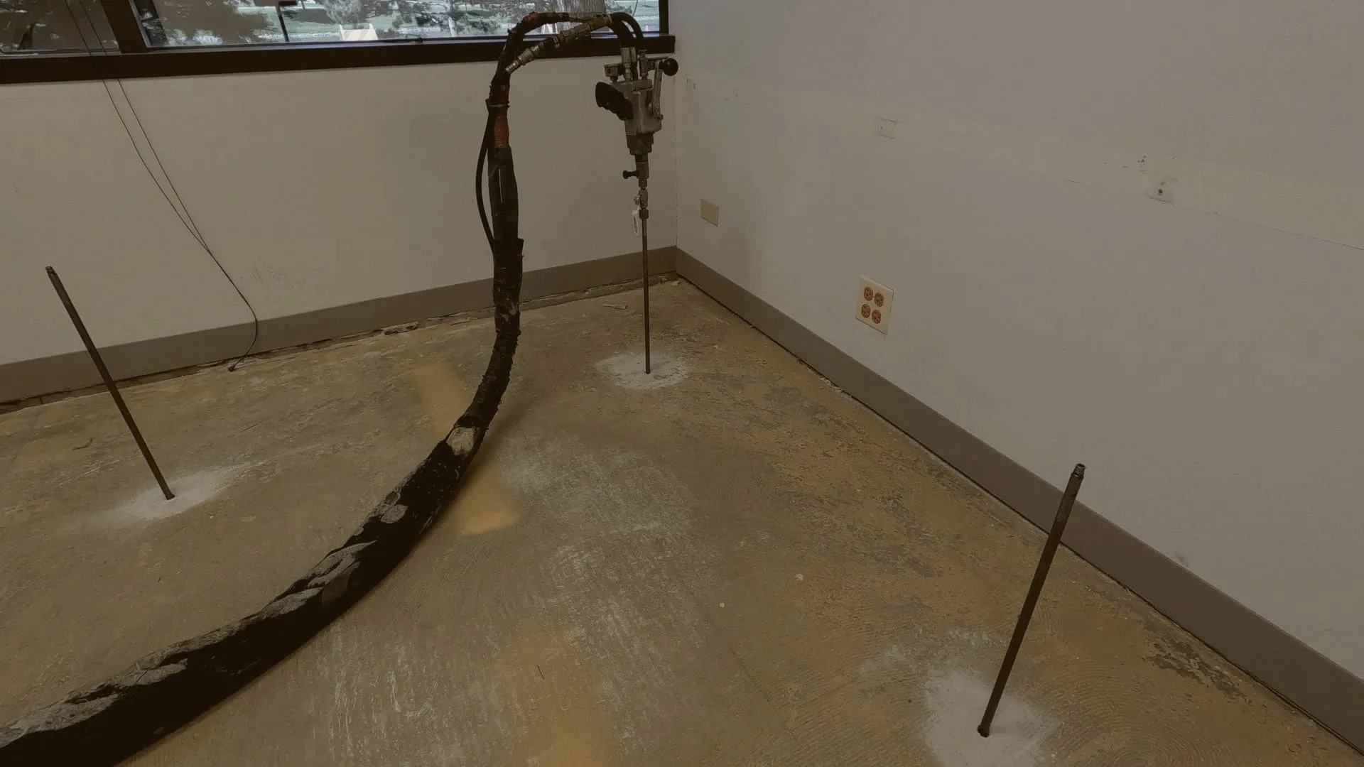 Injection rods set in an interior floor with the gun on its hose
