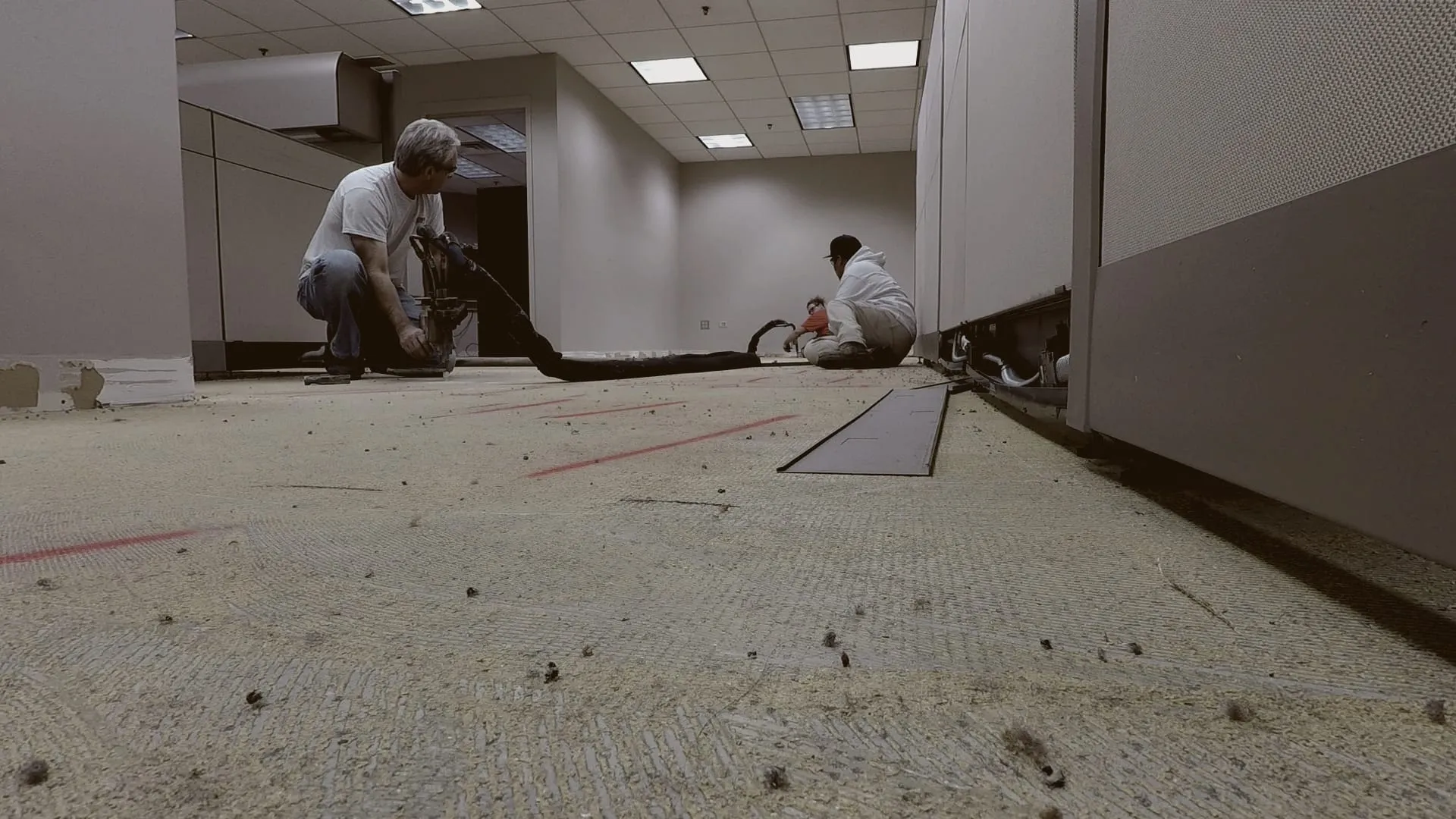 Crew injecting an office floor between cubicles