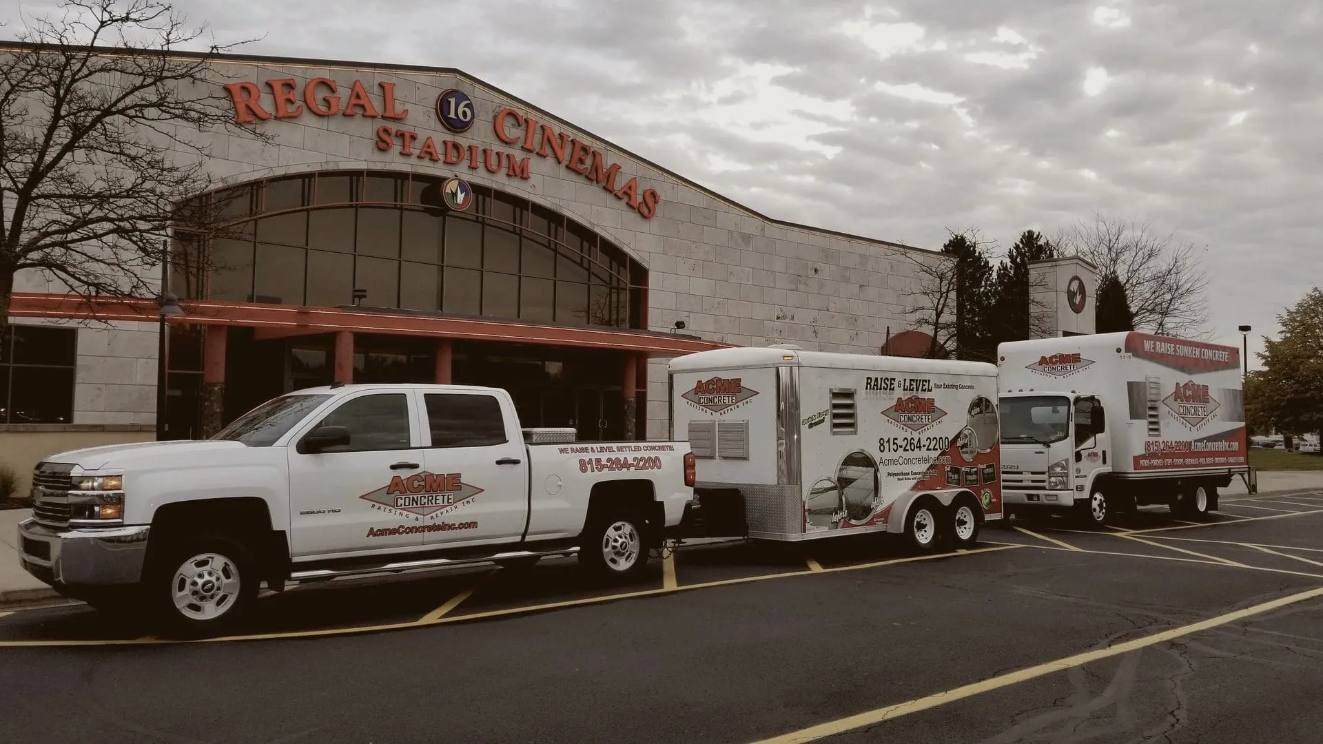 Acme pickup, trailer and box truck outside a Regal cinema