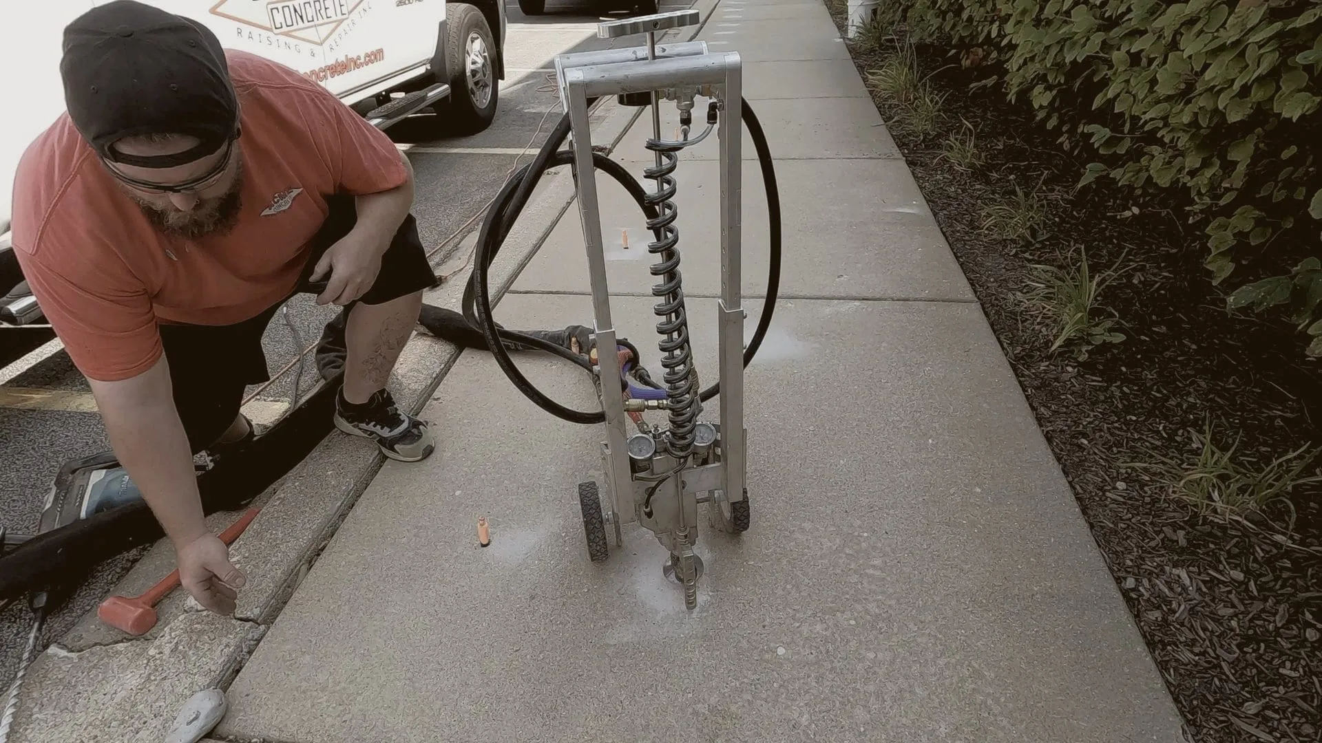Crew member with a wheeled injection cart on a commercial sidewalk