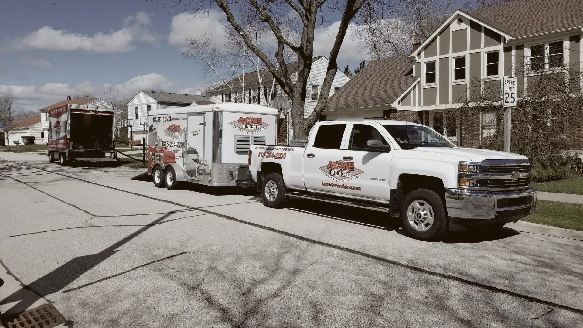 Acme pickup, trailer and box truck set up on a residential street