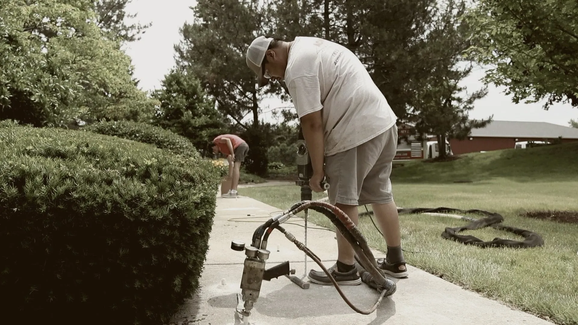 Crew drilling injection holes along a walkway